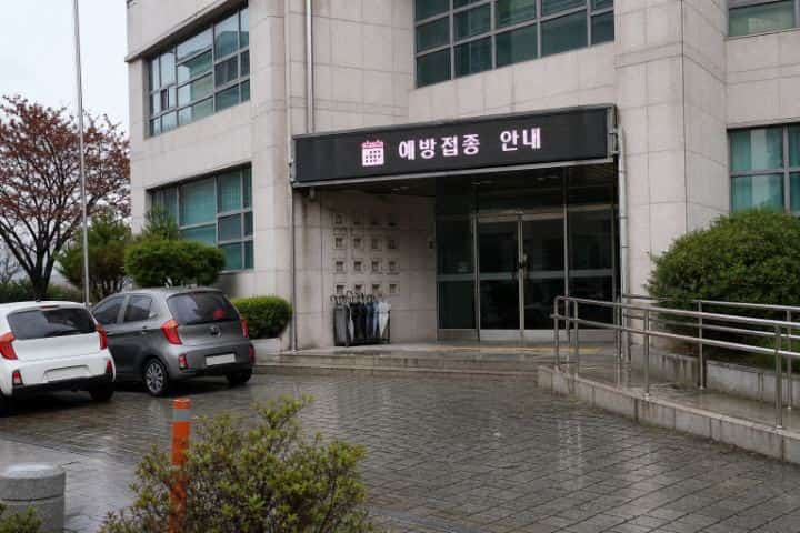 비 내리는 날 한국 보건소 현관 상단에 설치된 예방접종 안내 LED 전광판