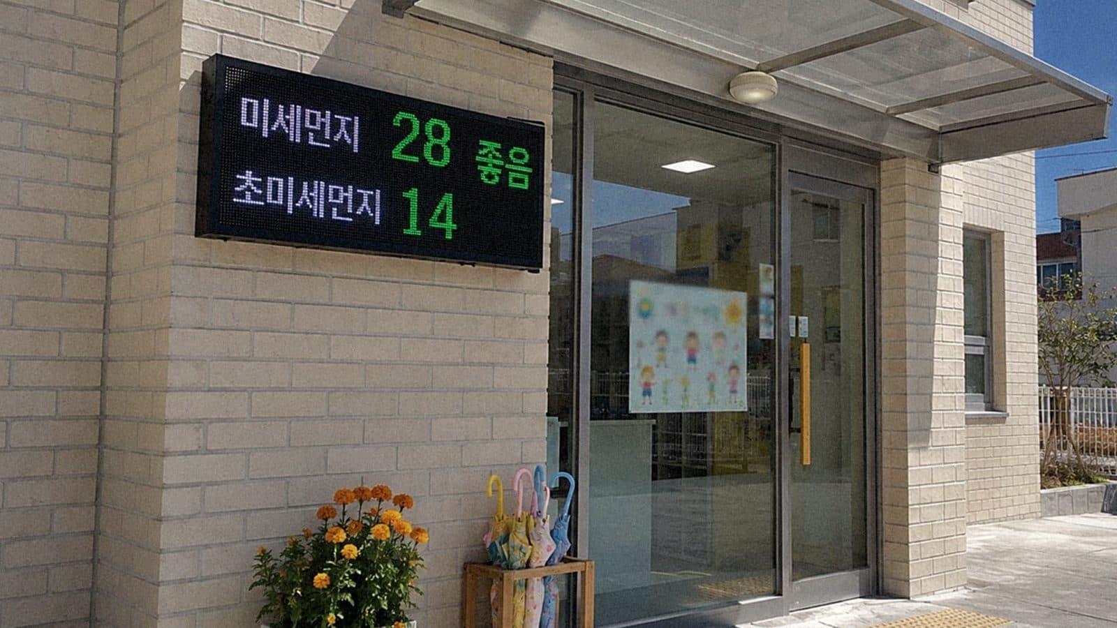 어린이집 현관 유리 캐노피 옆 벽돌 벽에 단 LED 전광판에 오늘 미세먼지와 초미세먼지 수치가 나오는 장면