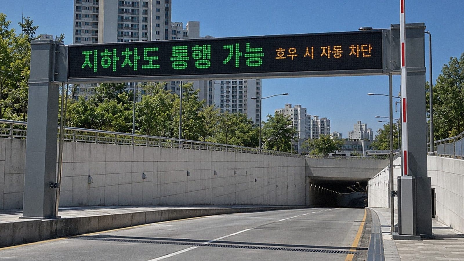 지하차도 입구 문형 구조물 보 위에 단 LED 전광판에 지하차도 통행 가능과 호우 시 자동 차단 안내가 나오는 장면