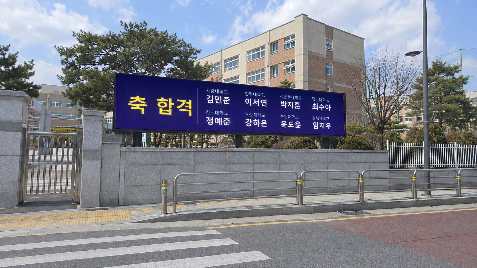 고등학교 정문 옆 담장 위 LED 전광판에 축 합격 문구와 졸업생 이름·합격 대학 명단이 표시된 모습