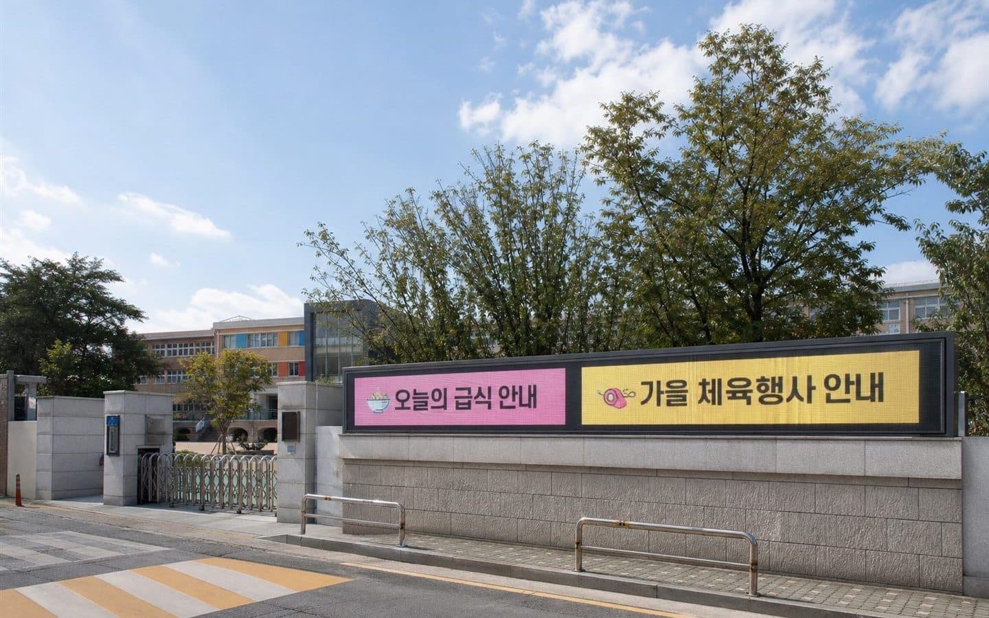 학교 담장에 설치된 두 칸짜리 화면이 오늘의 급식 안내와 가을 체육행사 안내를 나란히 표시하고 있다