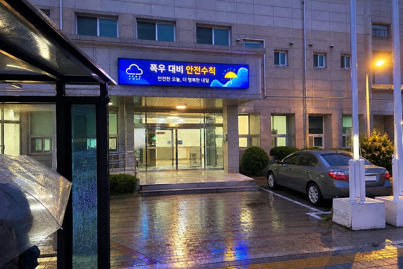 비 내리는 밤 건물 외벽 전자현수막에 폭우 대비 안전수칙이 표시된 장면
