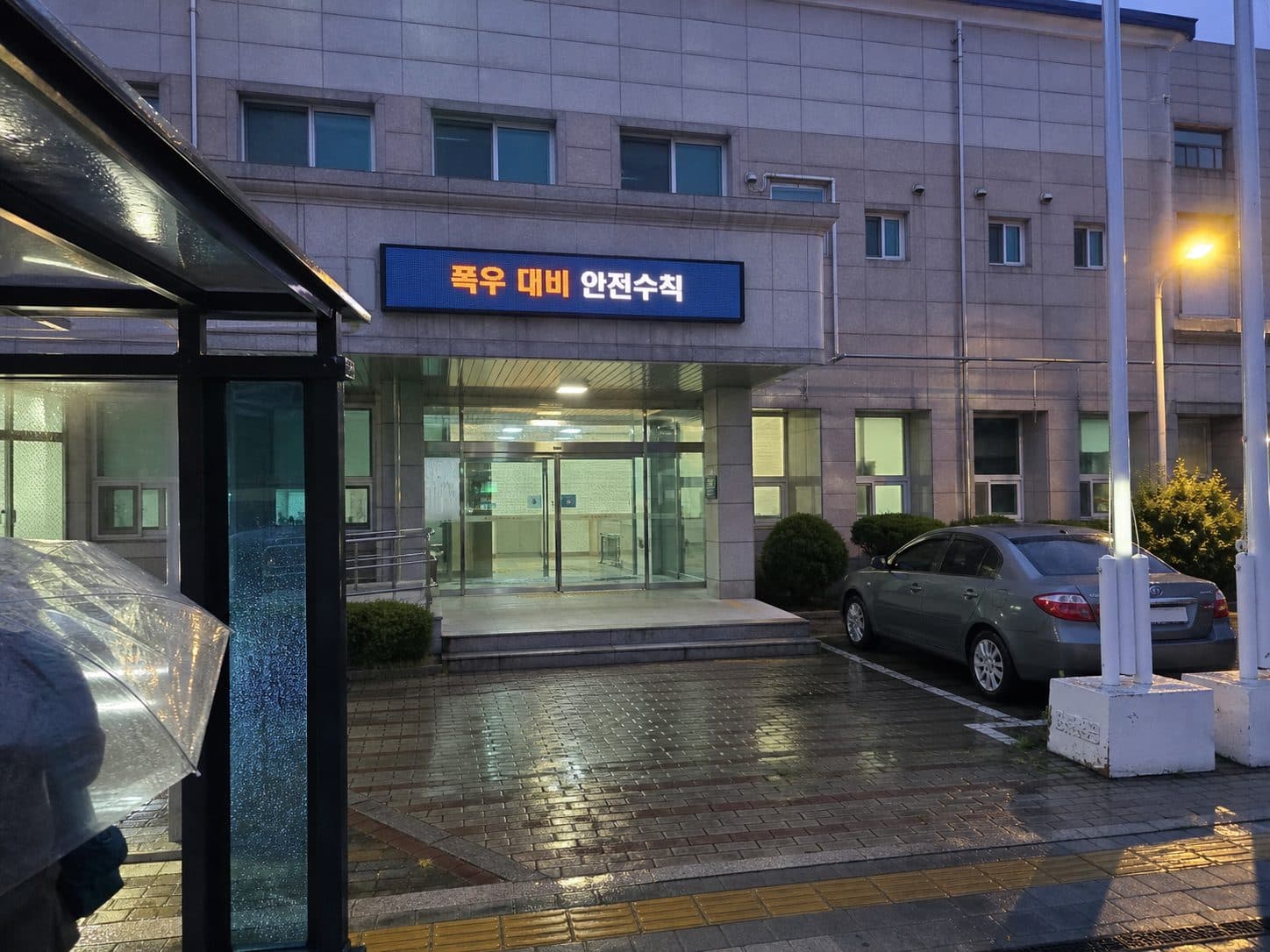 비 오는 저녁 한국 도로 위 전자현수막에 표시된 호우 안전 안내
