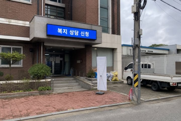 흐린 날 마을회관 출입구 위에 설치된 가로형 LED 안내 화면