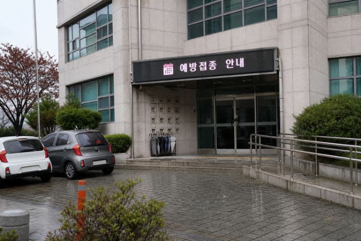 비 내리는 날 한국 보건소 현관 상단에 설치된 예방접종 안내 LED 화면