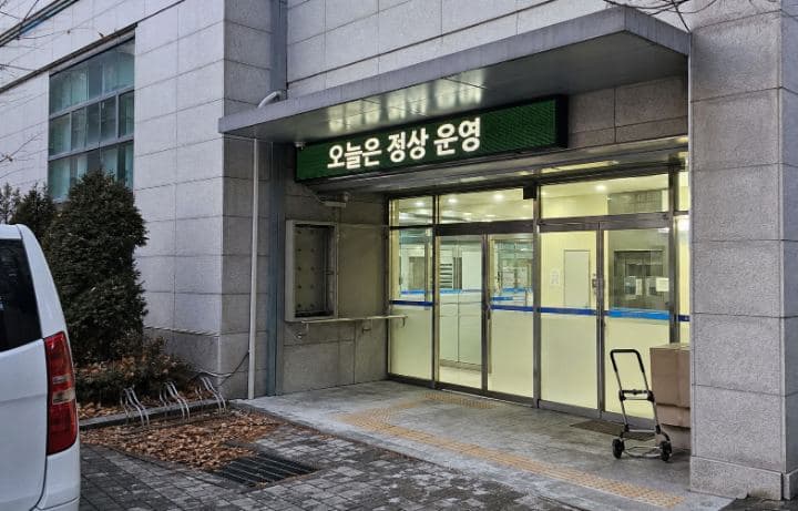 이른 아침 공공기관 출입구 위에서 당일 운영 안내를 표시하는 LED 화면
