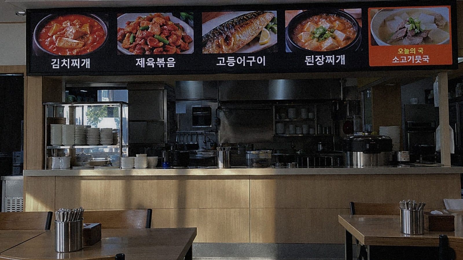 백반집 주문 카운터 위 벽에 단 실내 LED 전광판에 찌개·볶음 메뉴 사진과 오늘의 국이 나오는 장면